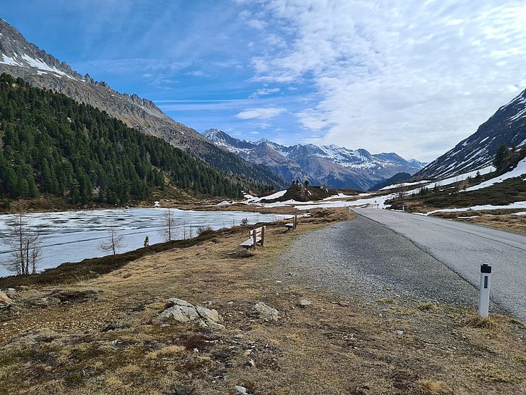 Bild vom Staller Sattel mit der Straße rechts und einem See links.